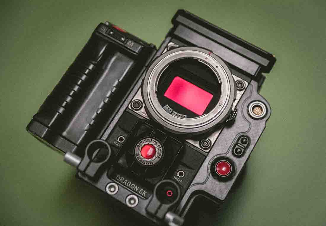 Black Dragon camera with red screen and buttons sits on green surface