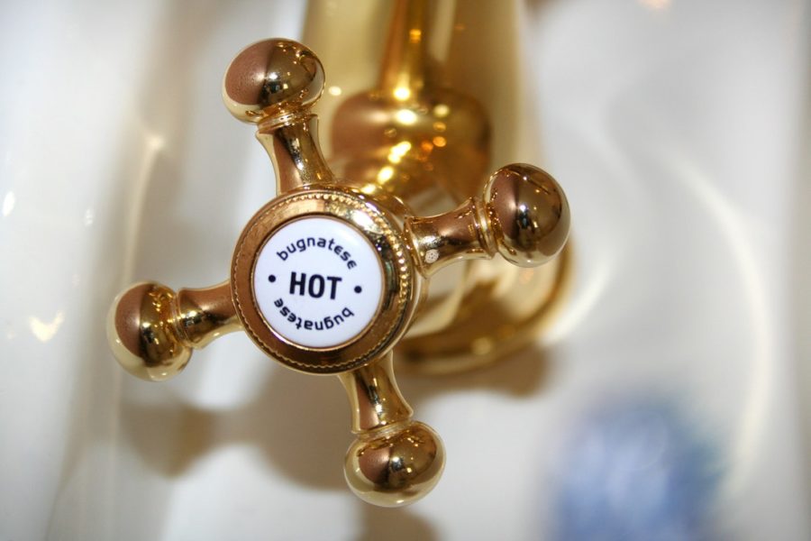 faucet valve gold color with hot written on it in the bathroom