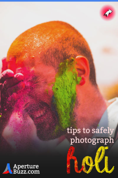 Man smearing colors on the face of another man during Holi festival in India