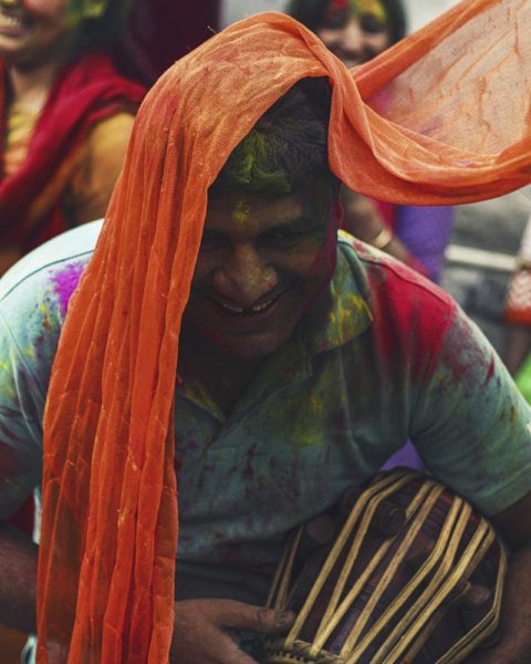Man playing a drum on the day of Holi