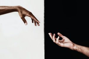 Two hands connecting over a black and white background