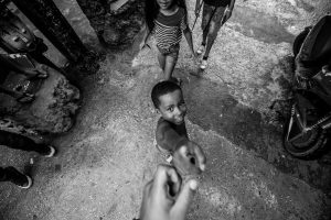 Street photograph of a young boy shaking hands with the photographer