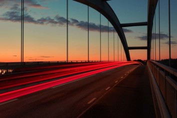 Long exposure image of a bridge with red and white light streaks of passing by cars