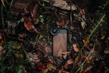 Mobile phone camera with external lens attached lying on a jungle floor