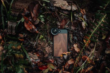 Mobile phone camera with external lens attached lying on a jungle floor