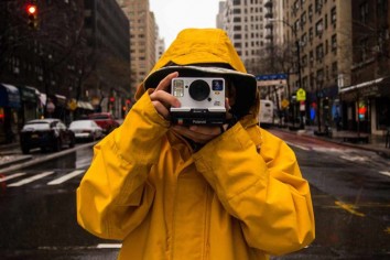A man shooting on a rainy day with a Polaroid camera