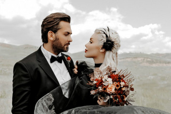 man-in-black-suit-holding-bouquet-of-flowers-panorama-portrait