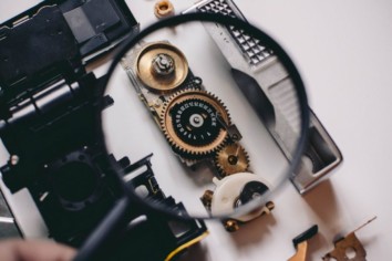 internal mechanics of a digital camera exposed with a magnification glass held above it