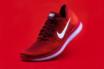 Red product display photograph of a Nike tennis shoe