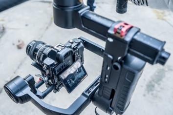 A DSLR camera mounted on a gimbal with an attached microphone ready to shoot a video